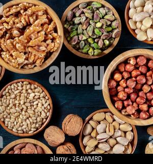 Nuts variety square design template. Various nuts in wooden bowls, overhead flat lay shot with copy space Stock Photo