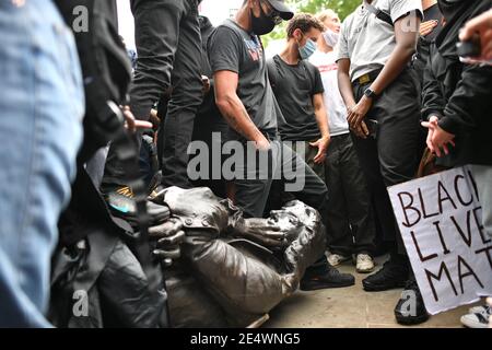 File photo dated 07/06/20 of the Edward Colston statue at the feet of protesters after being pulled down during a Black Lives Matter protest rally in College Green, Bristol. Four people will appear before Bristol Magistrates' Court on Monday charged with criminal damage following the toppling of a statue of slave trader Edward Colston in Bristol. Issue date: Monday January 25, 2021. Stock Photo