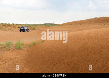 Surface of sand or soil wave lines after rain. Car on blur background. Stock Photo