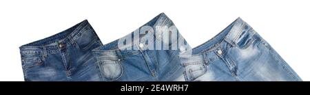 Waist and front pockets areas of three pairs of blue jeans slightly tilted on white background. Jeans have faded white spots and holes in them. Isolat Stock Photo