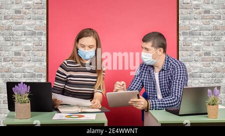 Creative young people with face mask working in modern coworking office space during startup business Stock Photo