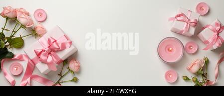 Panoramic banner of pink roses, candles and gift boxes on white, pink roses, a gentle Valentines Day banner with gift boxes Stock Photo