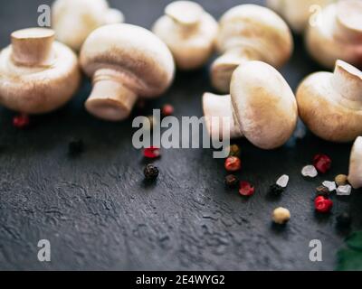 Mini champignons with copy space on left edge. Raw whole mushrooms on black background, copy space Stock Photo