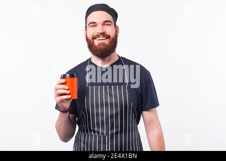 Photo of smiling chef man holding cup of coffee to take away. Stock Photo