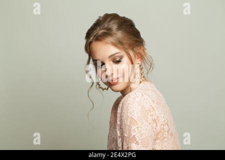 Magnificent young woman in pearls earring posing on white background Stock Photo