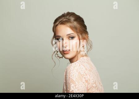 Beautiful young woman in pearls earring posing on white background Stock Photo