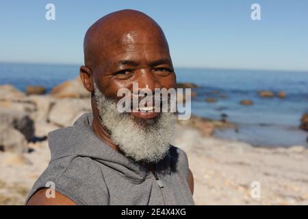 Portrait of fit senior african american man by the sea smiling. healthy retirement outdoor fitness lifestyle. Stock Photo