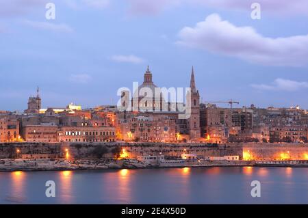 night view of Valletta with the belltower of St. Paul Cathedral and dome of Carmelite Church at the twilight Stock Photo