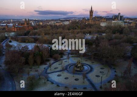 Glasgow, Scotland, UK. 25th Jan, 2021. Pictured: Glasgow's Kelvingrove Park with Glasgow University and the Art Galleries as seen from above. A cold and frosty morning with temperatures overnight dipping to -2C, as the sun rises, the temperature rises only to about  1C in some areas with icing and frost covering the ground. A warm morning glow in the west as the rising sun illuminates the city, showing Kelvingrove Park and Glasgow's west end area. Credit: Colin Fisher/Alamy Live News Stock Photo