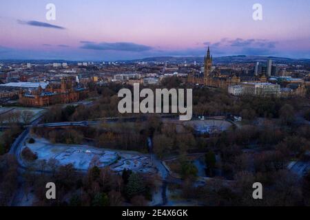 Glasgow, Scotland, UK. 25th Jan, 2021. Pictured: Glasgow's Kelvingrove Park with Glasgow University and the Art Galleries as seen from above. A cold and frosty morning with temperatures overnight dipping to -2C, as the sun rises, the temperature rises only to about  1C in some areas with icing and frost covering the ground. A warm morning glow in the west as the rising sun illuminates the city, showing Kelvingrove Park and Glasgow's west end area. Credit: Colin Fisher/Alamy Live News Stock Photo