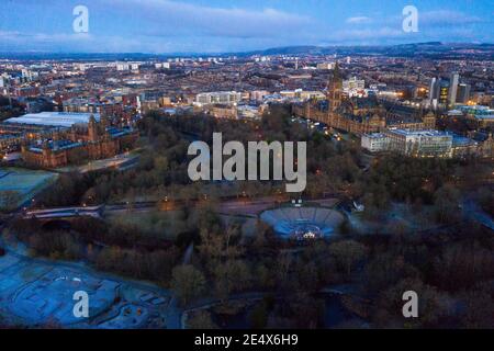 Glasgow, Scotland, UK. 25th Jan, 2021. Pictured: Glasgow's Kelvingrove Park with Glasgow University and the Art Galleries as seen from above. A cold and frosty morning with temperatures overnight dipping to -2C, as the sun rises, the temperature rises only to about  1C in some areas with icing and frost covering the ground. A warm morning glow in the west as the rising sun illuminates the city, showing Kelvingrove Park and Glasgow's west end area. Credit: Colin Fisher/Alamy Live News Stock Photo