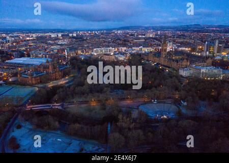 Glasgow, Scotland, UK. 25th Jan, 2021. Pictured: Glasgow's Kelvingrove Park with Glasgow University and the Art Galleries as seen from above. A cold and frosty morning with temperatures overnight dipping to -2C, as the sun rises, the temperature rises only to about  1C in some areas with icing and frost covering the ground. A warm morning glow in the west as the rising sun illuminates the city, showing Kelvingrove Park and Glasgow's west end area. Credit: Colin Fisher/Alamy Live News Stock Photo