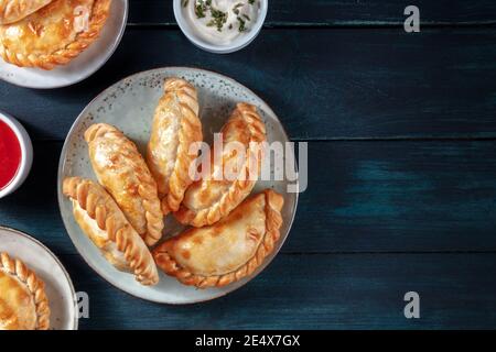 Empanadas dinner, shot from the top on a dark blue rustic wooden background with copy space Stock Photo