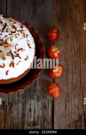 Easter cake and colored eggs. Rustic food on a wooden table. Traditional egg colored with onion peel. Clover and dill leaves pattern. Classic food for Stock Photo