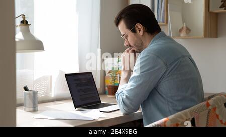 Focused young man author creating story using laptop app Stock Photo