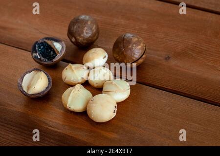 Organic macadamia nuts on wooden table. Selective focus. Superfood and healthy food concept Stock Photo