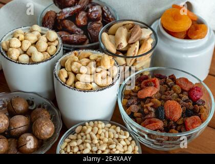 Dried fruits and nuts close up. Selective focus. Organic and healthy. Trail mix of almond, macadamia, pine, Brazil edible nuts, hazelnut, dates, dried Stock Photo