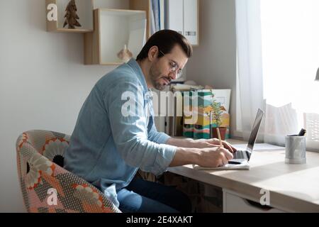 Young man making notes from online tutorial on distant learning Stock Photo
