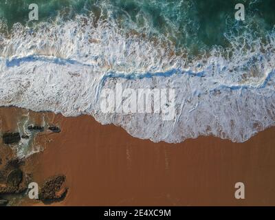 Aerial view of sea waves and sandy beach Stock Photo