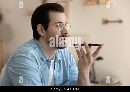 Confident young man communicating with friend by loud speaker Stock Photo