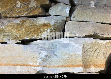 Stone wall in gray and brown natural color shade, background and texture of stone wall from large stone blocks, modern construction and architecture Stock Photo