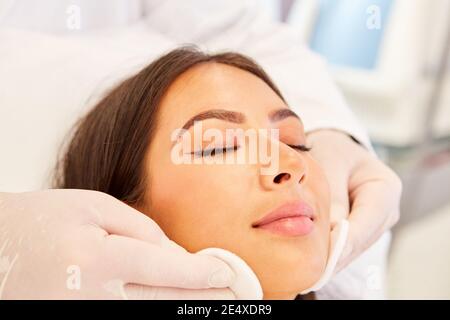 Professional skin cleaning with cotton pads for a young woman in the beauty salon Stock Photo