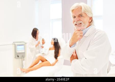 Doctor as smiling plastic surgery specialist in the beauty clinic Stock Photo