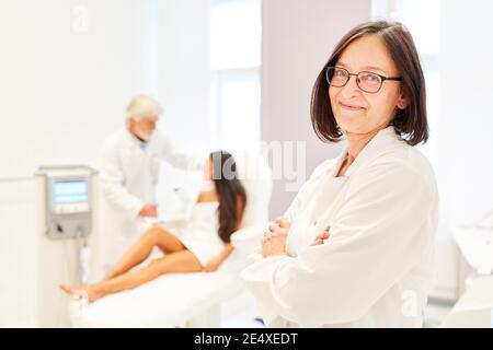Woman as a smiling plastic surgery doctor in the beauty clinic Stock Photo