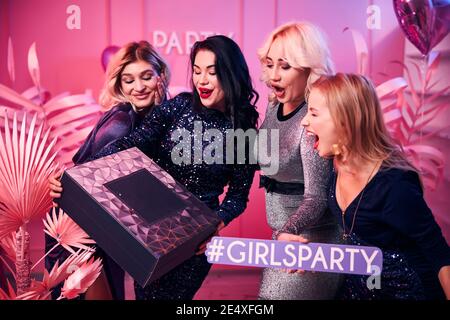 Pleased lady showing the present to her friends Stock Photo
