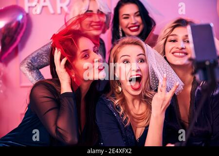 Five women taking selfies at the bridal shower