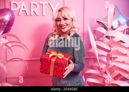 Happy woman with a present posing for the camera Stock Photo