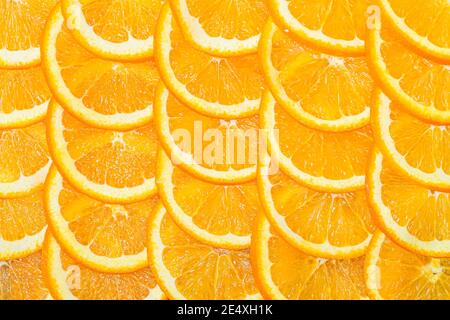 Abstract background with citrus-fruit of orange slices. Close-up. an orange cut into slices is lying on the table. Stock Photo