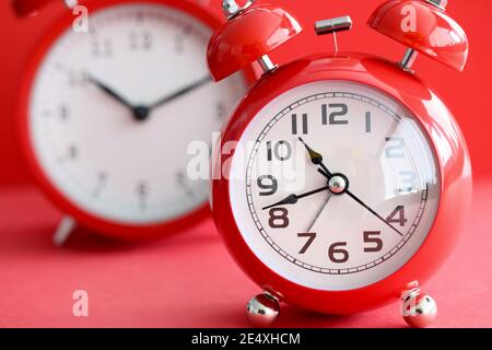 Two red alarm clocks with different times Stock Photo
