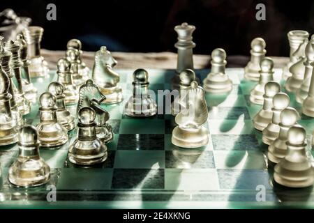 Glass chess pieces on board game Stock Photo