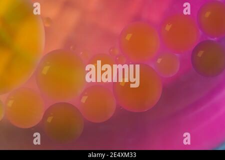 Blurred soft focus of oil spheres in water with color transition from orange to purple tones for colorful background Stock Photo