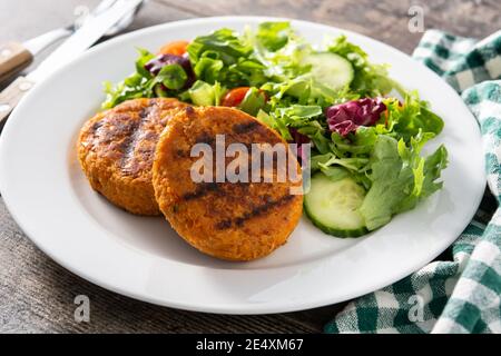 Delicious healthy chickpea burger and salad isolated on white background Stock Photo