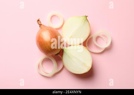 Fresh onion on a pink background, top view, a single onion bulb flat lay for vegetable, cooking and healthy food Stock Photo