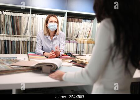 Salesman in medical mask advises client closeup Stock Photo