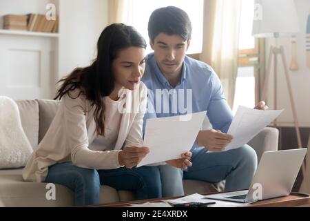 Close up serious young couple reading documents, calculating finances Stock Photo