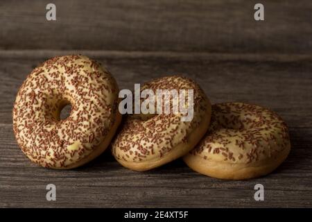 Delicious ring donuts covered with vanilla, topped with sprinkles. Stock Photo