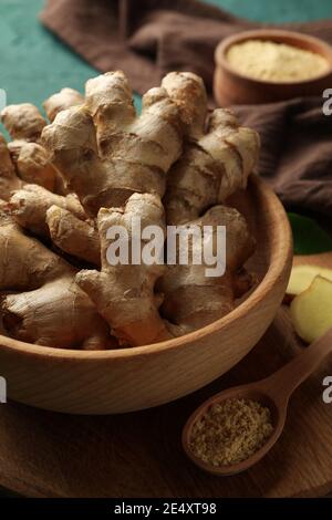 Board with fresh ginger on green background Stock Photo