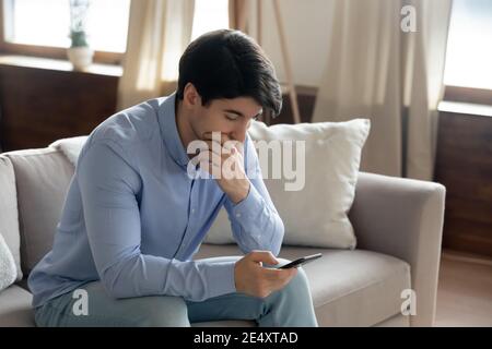 Close up thoughtful serious man using phone, having problem Stock Photo