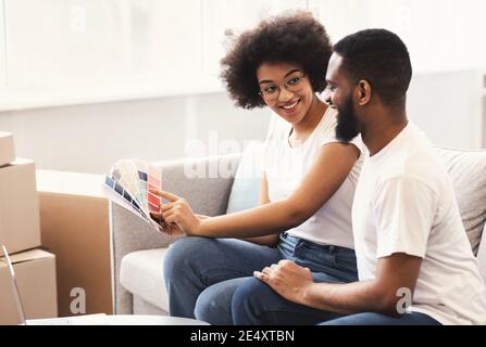 Happy Black Couple Planning Renovation After Moving House Sitting Indoor Stock Photo