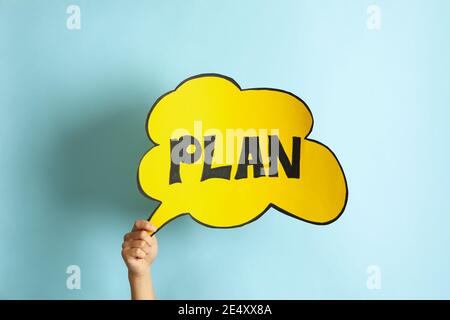 Female hand hold cloud with text Plan on blue background Stock Photo