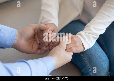 Close up loving husband holding wife hands, supporting and comforting Stock Photo