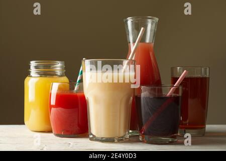 Glasses and jars with different juices on a white wooden table, a colorful healthy drink selection Stock Photo