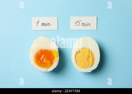 Boiled eggs with labels showing soft, medium and hard cooking time on a blue background, a kitchen guide concept Stock Photo