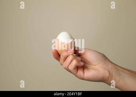 Female hand hold boiled egg on gray background Stock Photo