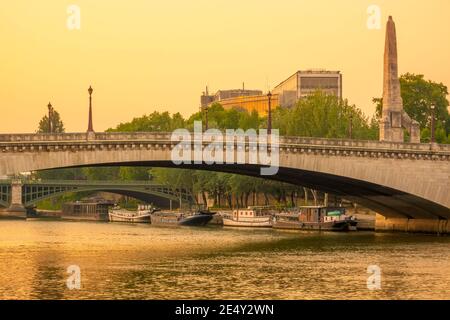 France, Paris. Summer evening over the bridges of the Seine. Residential barges are moored at the river bank Stock Photo