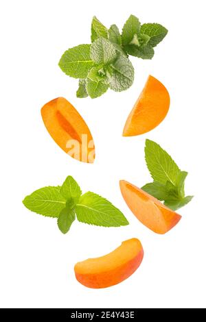 Falling down mint herb and apricots isolated on white background Stock Photo